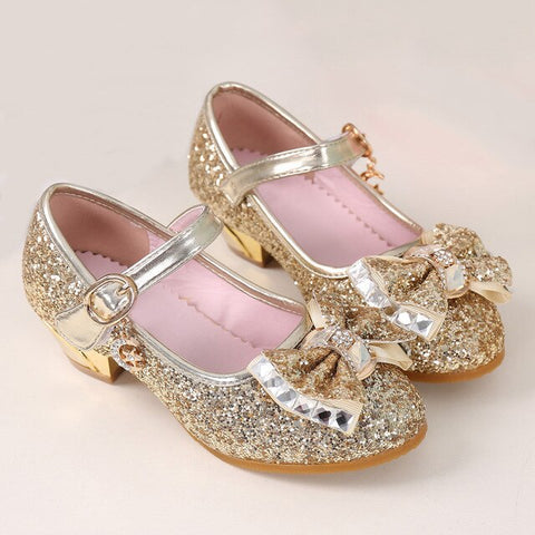 נעלי זהב של עקבים גבוהים עבור בנות.